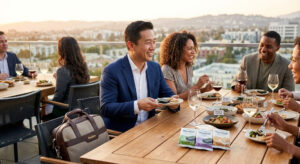 A professional man sharing Maadan clean-label Nori and Nurungji snacks with friends at a rooftop dinner, representing social freedom and food safety for those with gluten sensitivities.